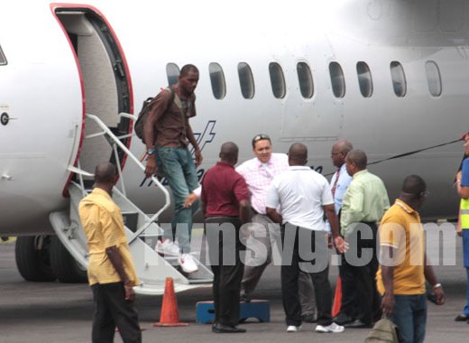 Wanted man Dwaine Sandy disembarks a LIAT flight from Grenada at the E.T. Joshua Airport as his lawyer, Grant Connell (facing camera) talks with police on Monday, June 17, 2013.