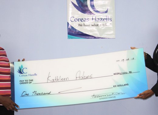 Kathleen Daniel-Adams, mother of Shelisa Adams receives cheque from Divisional Manager-Retail of Coreas Hazells Inc., Debbie Huggins.