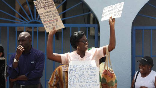 A woman holds placards with Scripture verses written on them at the National Day of Prayer Rally in Kingstown on Monday, June 10, 2013. (IWN photo)