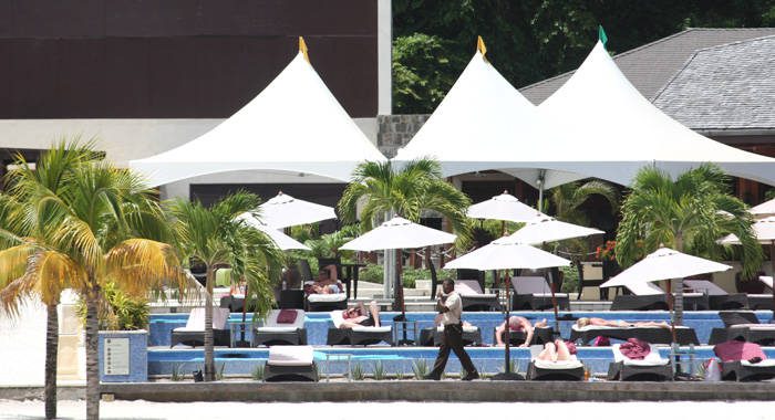 A security guard walks by as guests sunbathe at Buccament Bay Resort on July 4, 2013. (IWN photo)
