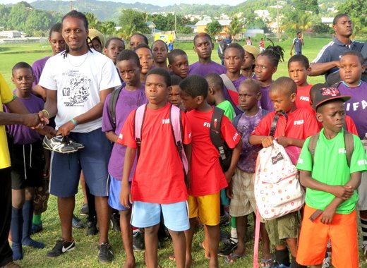 Manager of the Kenville Horne Sports Academy, Kenville Horne, right, receives the donation from Troumaca resident and community activist, Gideon Lewis.
