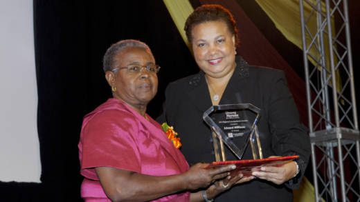 Photo Caption: Dawn Smith (left) collects Regional Unsung Hero Awardee 2012 Edward Williams award on his behalf from Managing Director, HR, CIBC FirstCaribbean, Ella Hoyos.