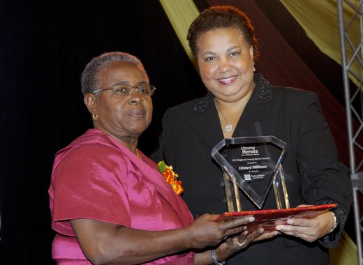 Photo Caption: Dawn Smith (left) collects Regional Unsung Hero Awardee 2012 Edward Williams award on his behalf from Managing Director, HR, CIBC FirstCaribbean, Ella Hoyos.