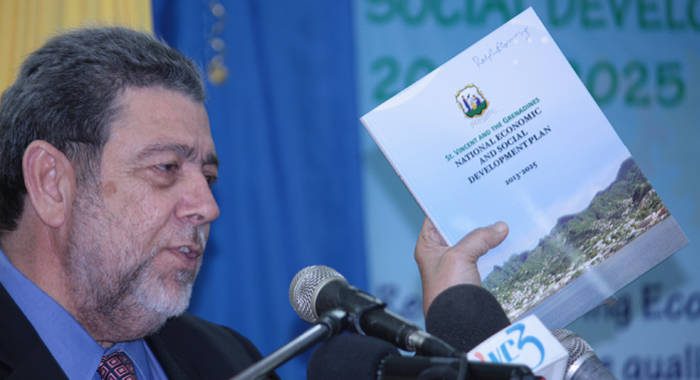 Prime Minister Dr. Ralph Gonsalves displays a copy of the Plan while making the feature address. (IWN photo)