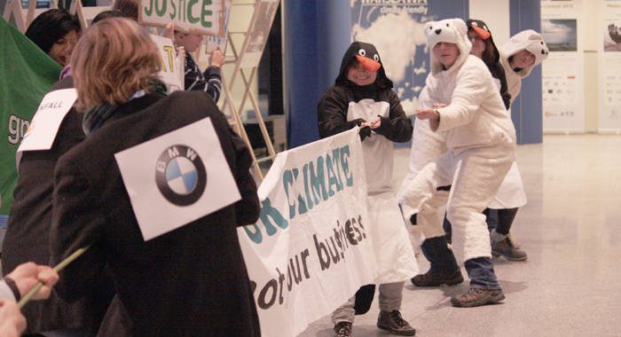 Young activists stage a mock tug-of-war at the climate talks to demonstrate the conflicting interest of big business and the environment. (IWN photo)