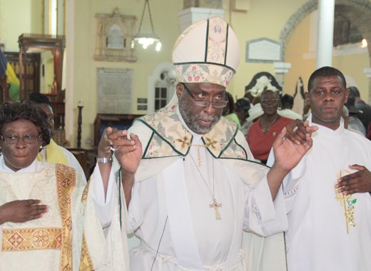The Right Reverend C. Leopold Friday, bishop of the Winward Islands, centre, and newly ordained deacons, Hanif H.R. Johnson, right and Alison M. Samuel during the recession. (IWN photo)