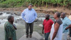 Prime Ministers Spencer, left, and Gonsalves, right, chat with Joseph Da Silva, whose South Rivers business was damaged. (IWN photo)