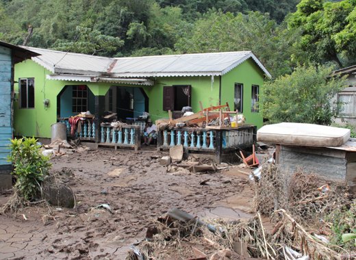 Floodwaters have damaged or destroyed many houses, like this one in Spring Village, N. Leeward. (IWN photo)