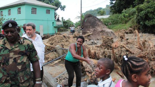 Acting Commissioner of Police, Michael Charles, left, and Prime Minister Dr. Ralph Gonsalves, during the tour of North Leeward on Friday. (IWN photo)