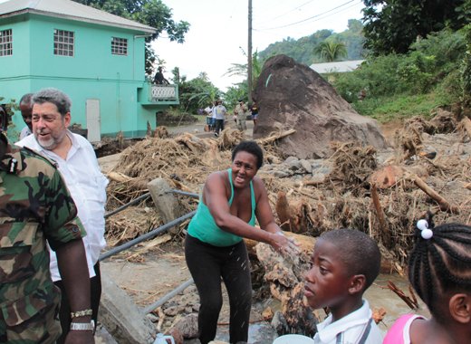 Acting Commissioner of Police, Michael Charles, left, and Prime Minister Dr. Ralph Gonsalves, during the tour of North Leeward on Friday. (IWN photo)