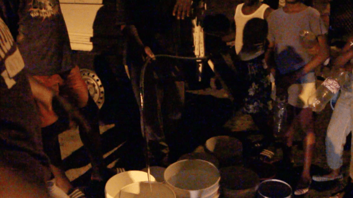 Residents of Rillan Hill, S. Leeward, fill up water from a truck Friday night. (IWN image)