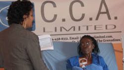Kidney patient, Catherine Sergeant, receive the CCA Ltd. Check from Camille Crichton. (IWN photo)