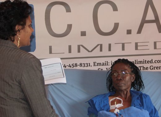 Kidney patient, Catherine Sergeant, receive the CCA Ltd. Check from Camille Crichton. (IWN photo)