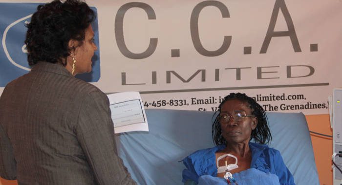 Kidney patient, Catherine Sergeant, receive the CCA Ltd. Check from Camille Crichton. (IWN photo)