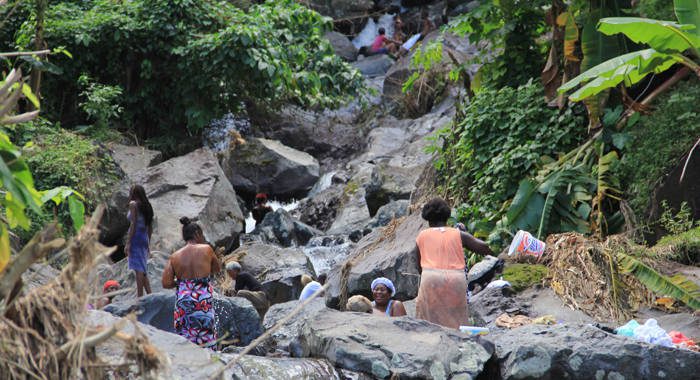 Residents of North Windward bathe in a river on Tuesday, Dec. 31, 2013. Water was yet to be reconnected there, one week after the disaster. (IWN photo)
