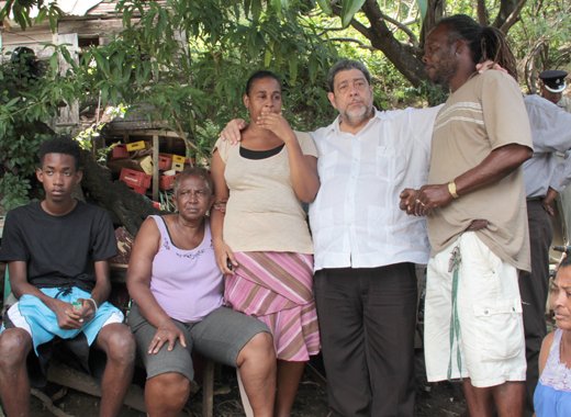 Prime Minister Ralph Gonsalves visits a family in Rose Bank where five persons died on Christmas Eve. (IWN photo)