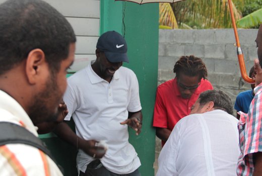 Prime Minister Ralph Gonsalves, second right, chat with disaster victims during the distribution of relief items in Buccament Bay on Jan. 24, 2014. (IWN photo) 