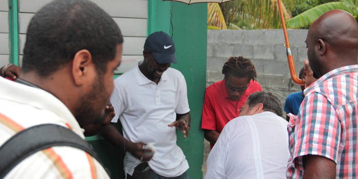 Prime Minister Ralph Gonsalves, second right, chat with disaster victims during the distribution of relief items in Buccament Bay on Jan. 24, 2014. (IWN photo) 
