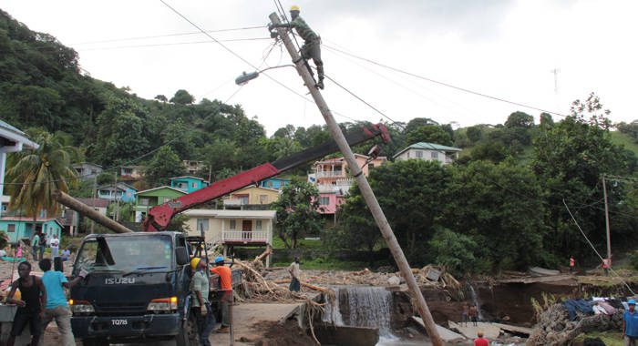 A worker repairs a damaged pole in North Leeward after the December 2013 floods. (iWN photo)
