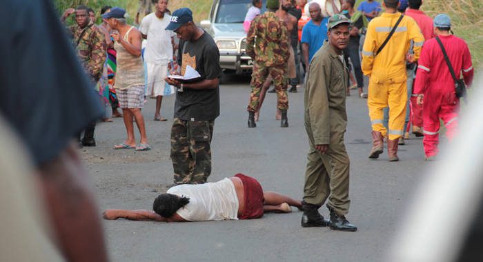 Police officers conduct investigation as the body of Nolly Jack lies on the road in Lowmans Bay. (IWN photo)