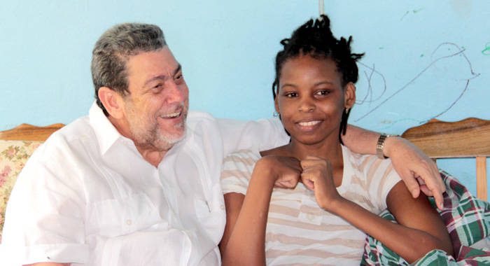 Prime Minister Ralph Gonsalves chats with Sweet-I Robertson at her home in Chateaubelair on Saturday. (IWN photo) 