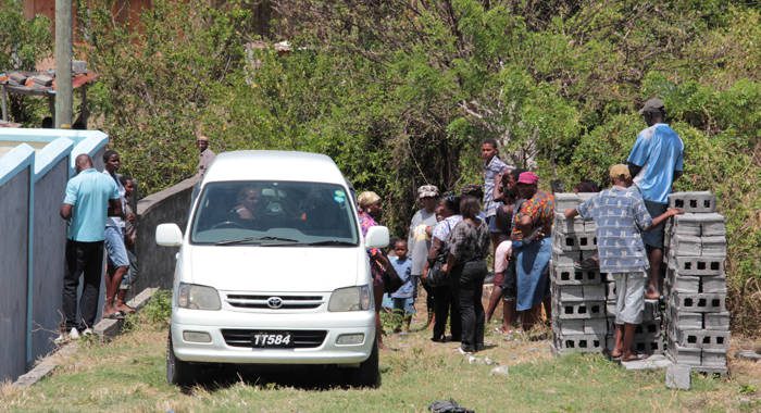 Villagers gather around a funeral home vehicle containing the body of Roger Bramble, which was found in Brighton on Monday. (Photo: IWN) 