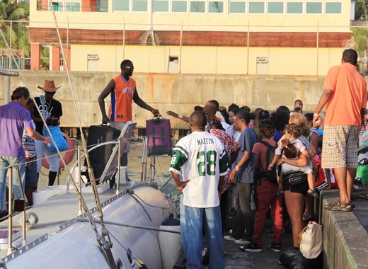 Passengers disembark a catamaran that ferried them from Union Island to Kingstown on Monday. (IWN photo)