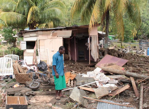 A Buccament Bay resident survey damage after the Christmas Eve trough system. (IWN photo)