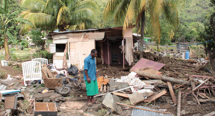 A Buccament Bay resident survey damage after the Christmas Eve trough system. (IWN photo)