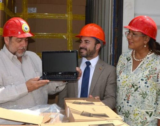 Prime Minister Ralph Gonsalves (left) examines one of the laptops on their arrival in St. Vincent. (Photo: Lance Neverson/Facebook)