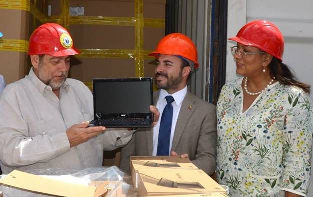 Prime Minister Ralph Gonsalves (left) examines one of the laptops on their arrival in St. Vincent. (Photo: Lance Neverson/Facebook)