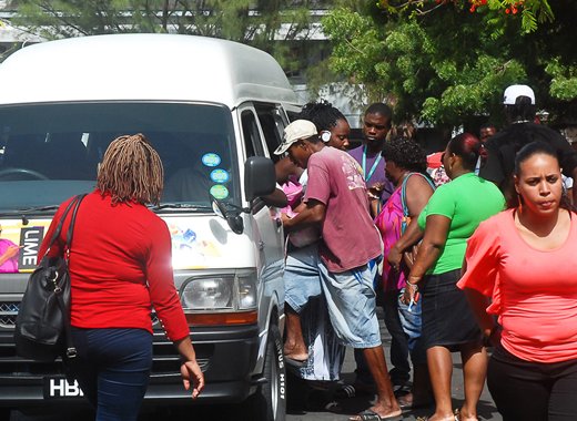 Persons board a minivan in Kingstown in June 2014. (Photo: Robertson Henry)
