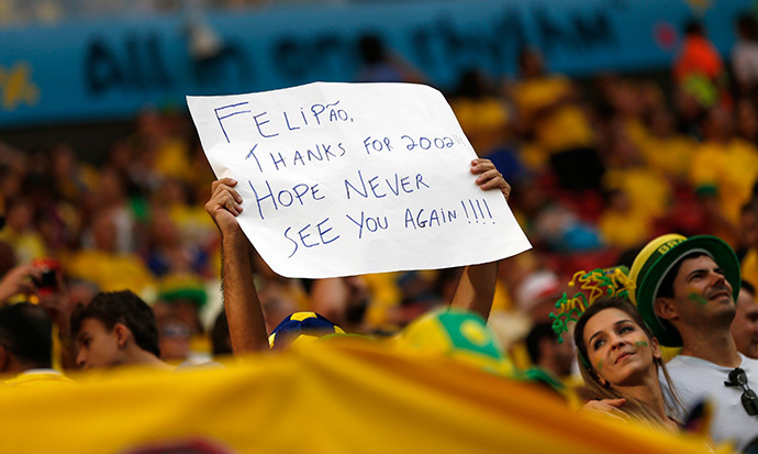 A Brazil fan waves a sign targeted at Brazil's coach Luiz Felipe Scolari before the 2014 World Cup third-place playoff between Brazil and the Netherlands at the Brasilia national stadium in Brasilia July 12, 2014. (Reuters / Ueslei Marcelino)