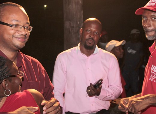 Grenville is hugged after the meeting. Carlos James, the ULP's candidate for N. Leeward, and activist Grantley Williams are centre and right. (IWN photo)