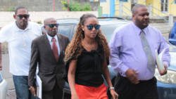 Former Registrar Tamara Gibson-Marks arrives at the Kingstown Magistrate's Court, accompanied by police officers and her lawyer, Alberton Richelieu (in suit). (IWN photo)