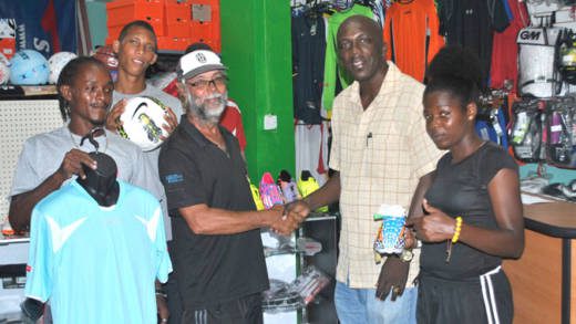 Michael John, manager of COMSPORT, left, and Coach Ian Sardine of System 3 and other members of the club.