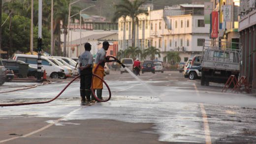 Firefighters use hoses to wash dust from Bay Street, Kingstown late Monday afternoon.  (IWN photo)