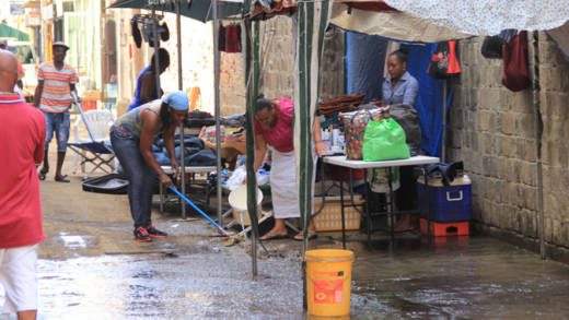 Vendors wash away dust in Middle Street, Kingstown Monday Morning.