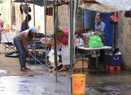 Vendors wash away dust in Middle Street, Kingstown Monday Morning.