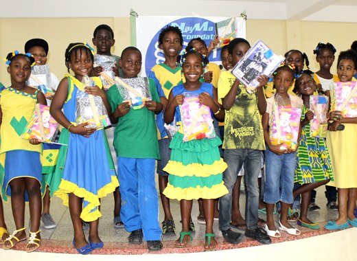 Children pose with the items donated by Tizana Goodluck-Hedge.