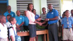 Junior Simmons of the Police Credit Union hands over the seedlings.