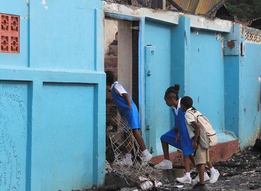 St. Mary's RC students on Monday look inside the shell of the Verbeke Centre, which was gutted by fire Friday night. (IWN photo) 