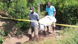 Funeral home employees remove Paul Spence's body from his home in Barrouallie. (IWN photo)