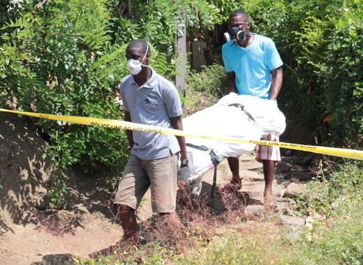 Funeral home employees remove Paul Spence's body from his home in Barrouallie. (IWN photo)