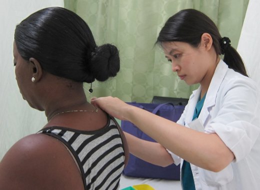 A Taiwanese professional provides healthcare to a woman in St. Vincent.  