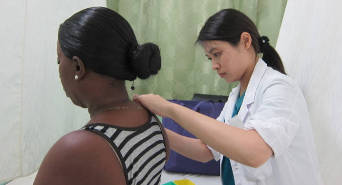 A Taiwanese professional provides healthcare to a woman in St. Vincent.  