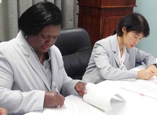 Michelle Forbes, deputy director of NEMO, left, and Tomoko Nikai of the International Cooperation System signing the agreement.