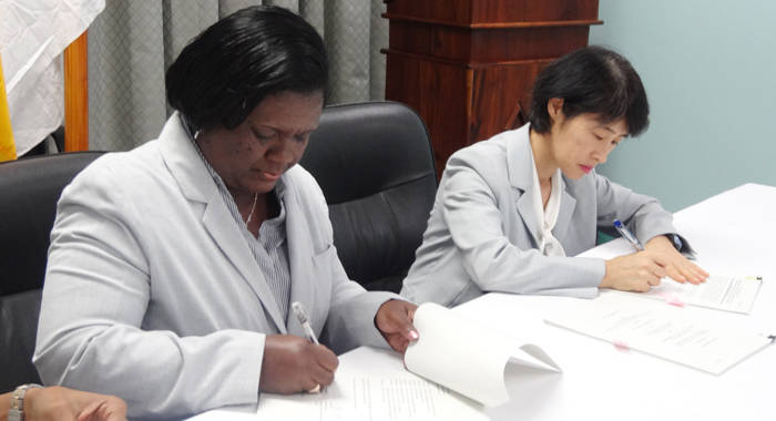 Michelle Forbes, deputy director of NEMO, left, and Tomoko Nikai of the International Cooperation System signing the agreement.