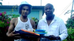 Derrance Lavia is presented with the fishing equipment by Lauron "Sharer" Baptiste. (Photo: Bryan Alexander/Facebook)