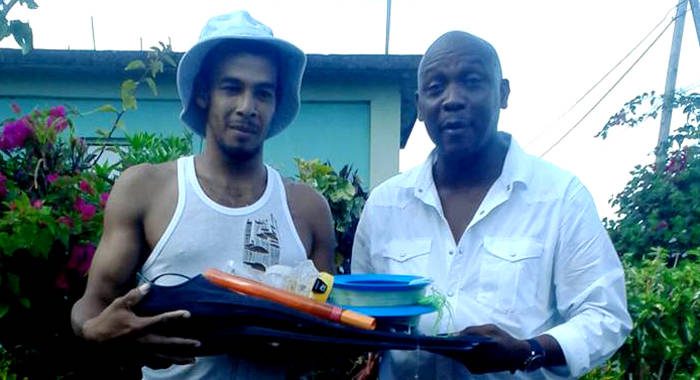 Derrance Lavia is presented with the fishing equipment by Lauron "Sharer" Baptiste. (Photo: Bryan Alexander/Facebook)